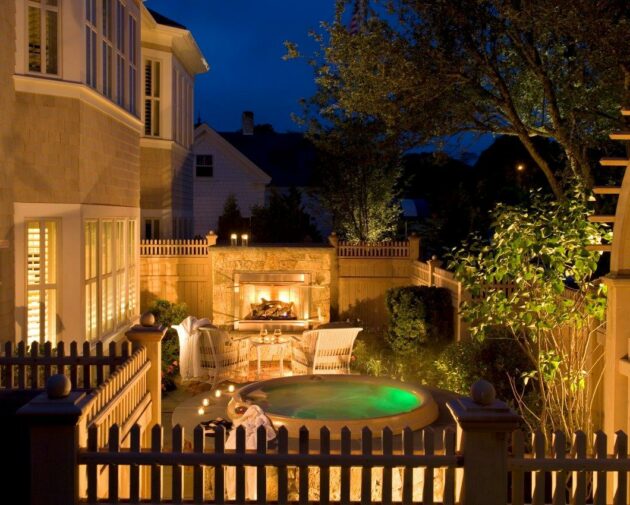 Outdoor jacuzzi and fireplace with chairs nearby at Wequassett Resort