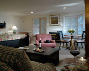 Hotel room living area with a bed, couches, and table with chairs.