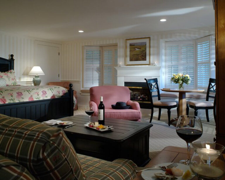 Hotel room living area with a bed, couches, and table with chairs.