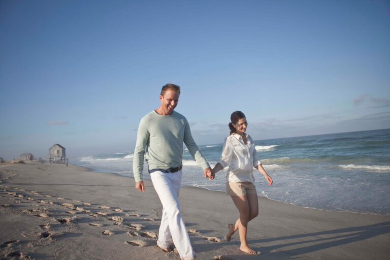 A couple walking together on the beach.